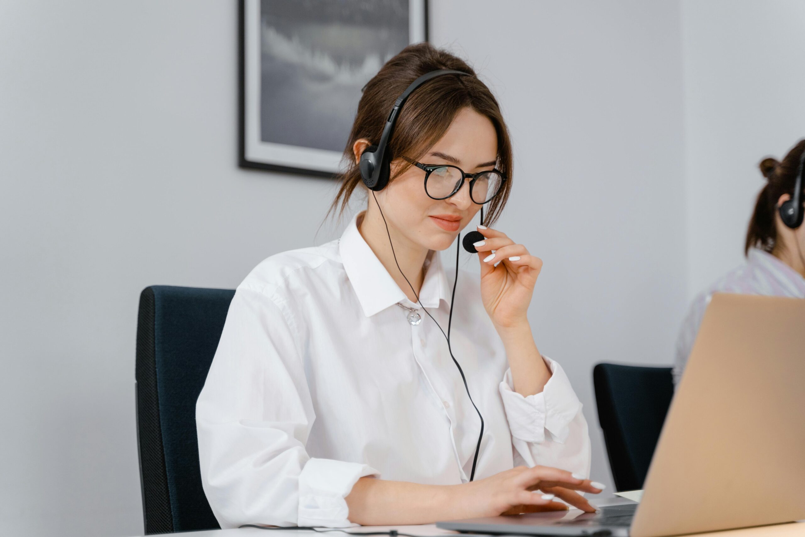 woman using a headset and computer speaking to a customer